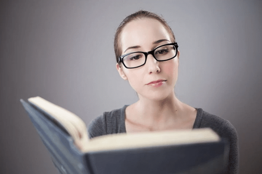 woman reading a book while wearing ready readers