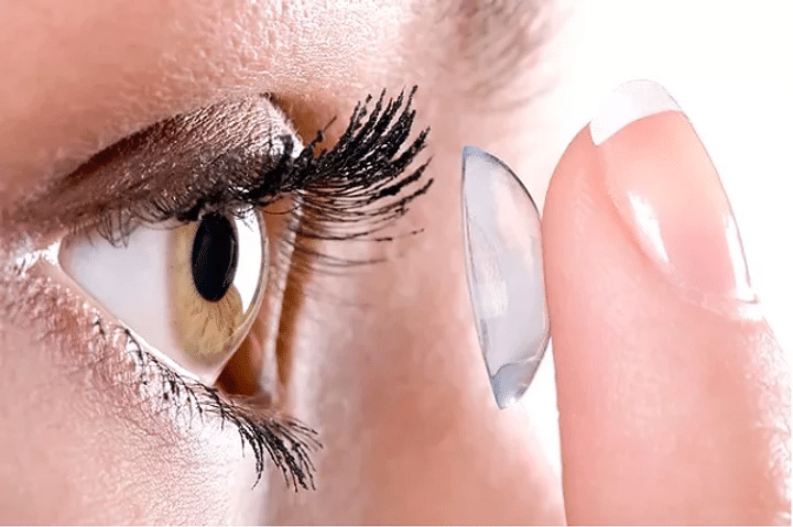 Woman applying contact lenses on