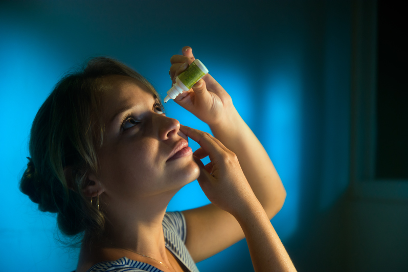 woman using eye drops to help with epiphora