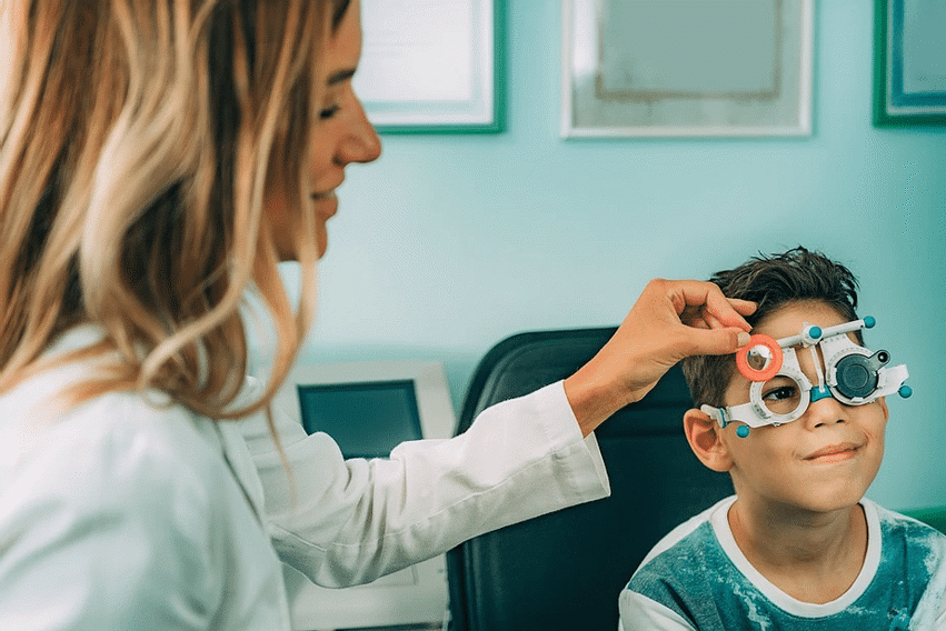 Kid having his eyes tested by an optician
