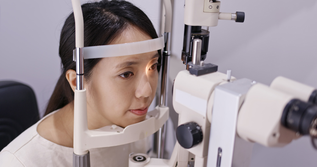 Asian woman undergoing a slit lamp test to check for cataract