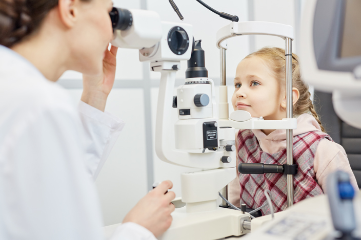 Kid having an eye exam with an optician