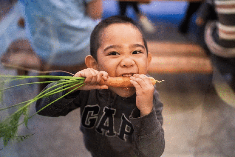 Kid eating carrot to improve his eyesight