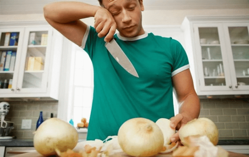 men cutting onions and crying