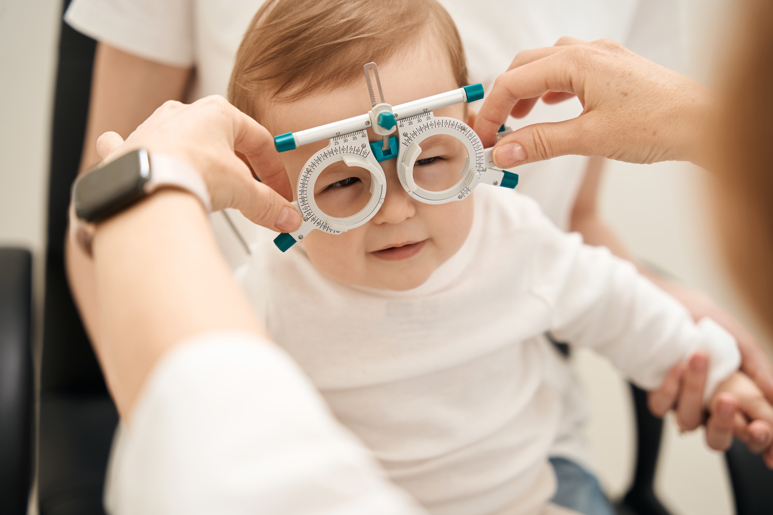 Optician testing a young kids eyes